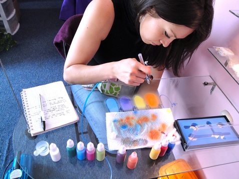 mujer pintando con aerógrafo y pinturas